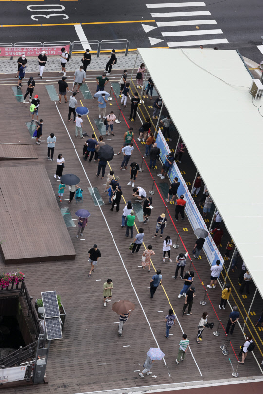 8일 오전 서울시 성북구청 앞 임시 선별진료소에 시민들이 검사를 위해 길게 줄지어 서 있다. 연합뉴스